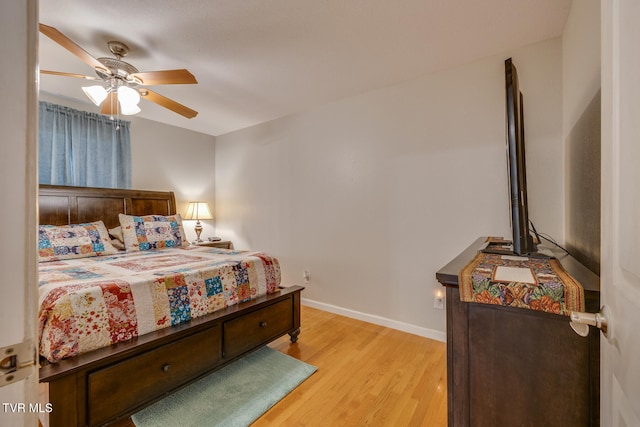 bedroom with light wood-type flooring, baseboards, and a ceiling fan