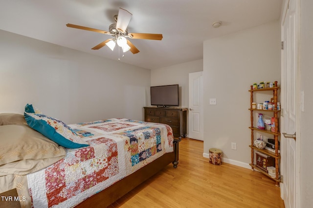 bedroom featuring light wood-type flooring, a ceiling fan, and baseboards