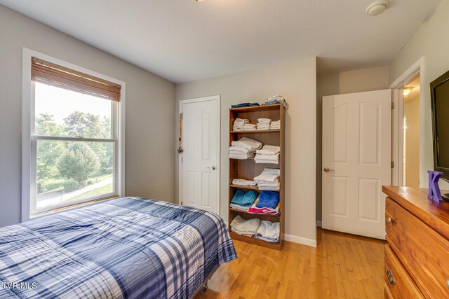 bedroom with light wood-style floors and baseboards