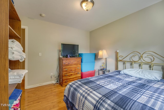 bedroom featuring light wood-style flooring and baseboards