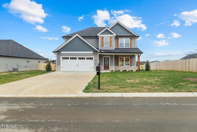 craftsman inspired home with a front yard, a porch, a garage, and central AC unit