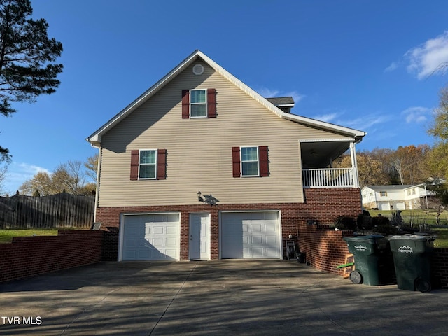 rear view of property featuring a garage and a balcony