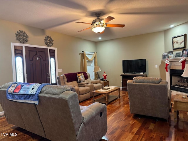 living room featuring a textured ceiling, dark hardwood / wood-style flooring, and ceiling fan