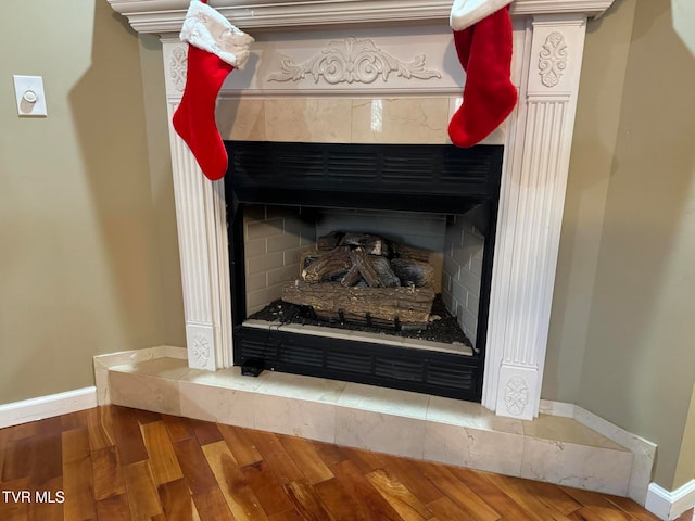 room details with a fireplace, hardwood / wood-style flooring, and tasteful backsplash