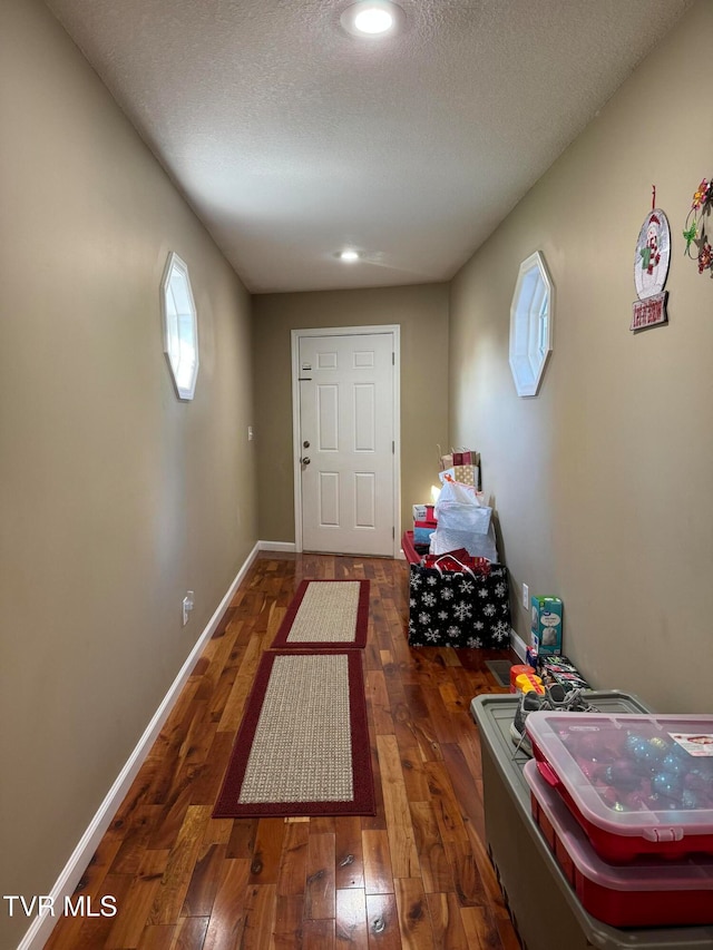 entryway with dark hardwood / wood-style floors and a textured ceiling