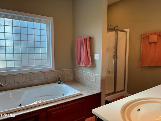 bathroom with vanity and shower with separate bathtub