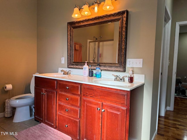 bathroom featuring a shower, wood-type flooring, vanity, and toilet