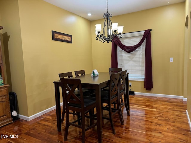 dining room with hardwood / wood-style flooring and a notable chandelier