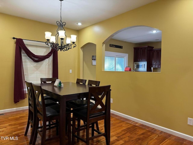 dining room featuring dark hardwood / wood-style flooring and a chandelier