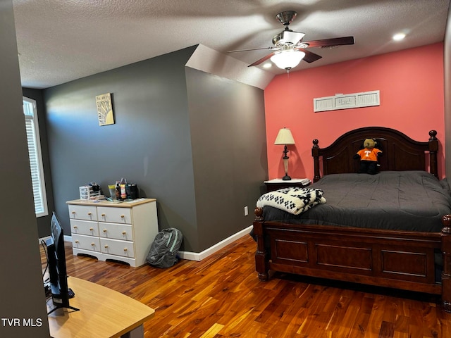 bedroom featuring a textured ceiling, dark hardwood / wood-style floors, and ceiling fan