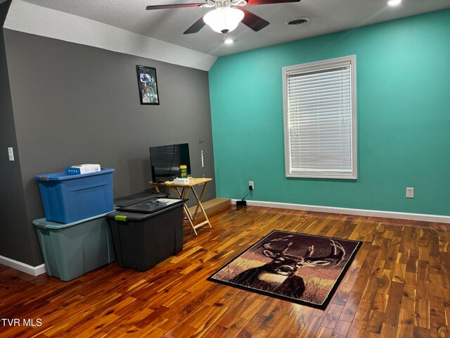 home office with dark hardwood / wood-style floors, ceiling fan, and vaulted ceiling