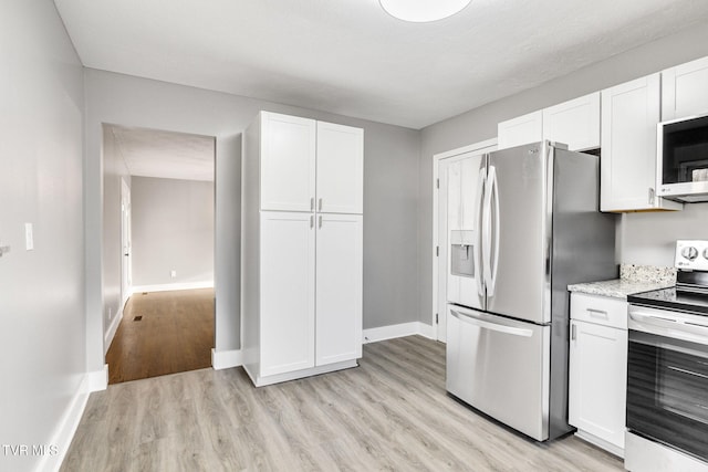 kitchen with white cabinets, light wood-type flooring, and appliances with stainless steel finishes