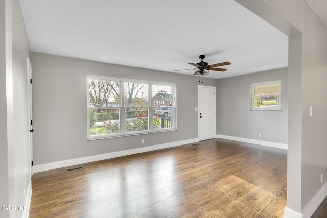 spare room with hardwood / wood-style floors, ceiling fan, and a healthy amount of sunlight