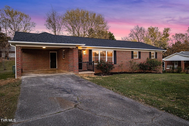 ranch-style house with a yard and a carport