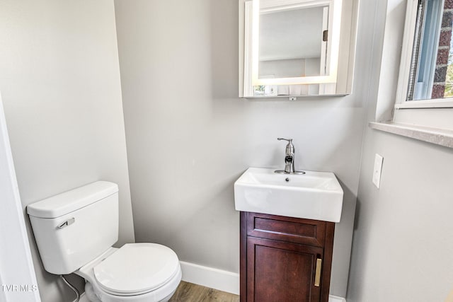 bathroom with hardwood / wood-style floors, vanity, and toilet