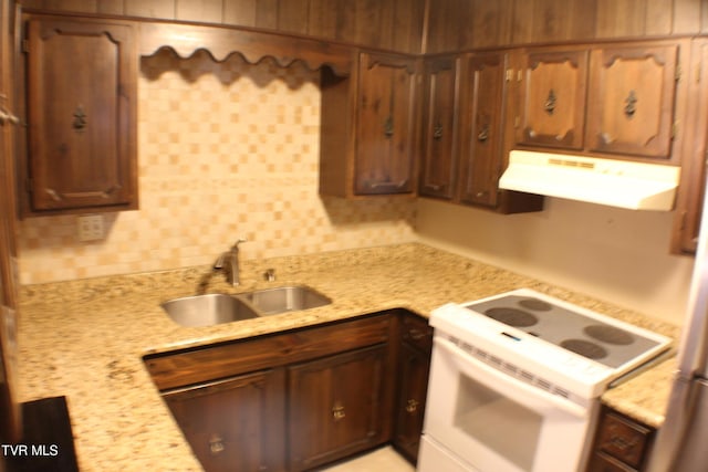 kitchen featuring light stone countertops, electric range, backsplash, and sink