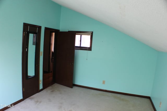 bonus room with light carpet, a textured ceiling, and vaulted ceiling