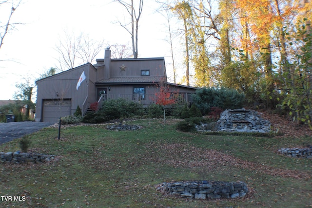 back of property featuring a yard and a garage