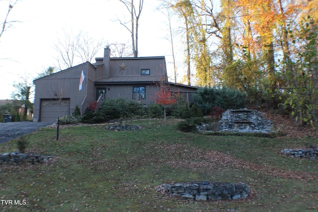 rear view of property with a lawn and a garage