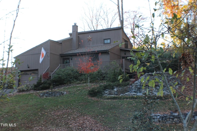 rear view of house featuring a yard and a garage