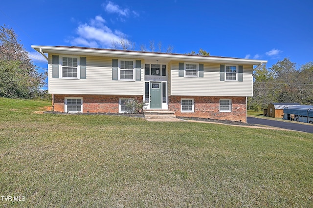 split foyer home with a front lawn and a storage shed