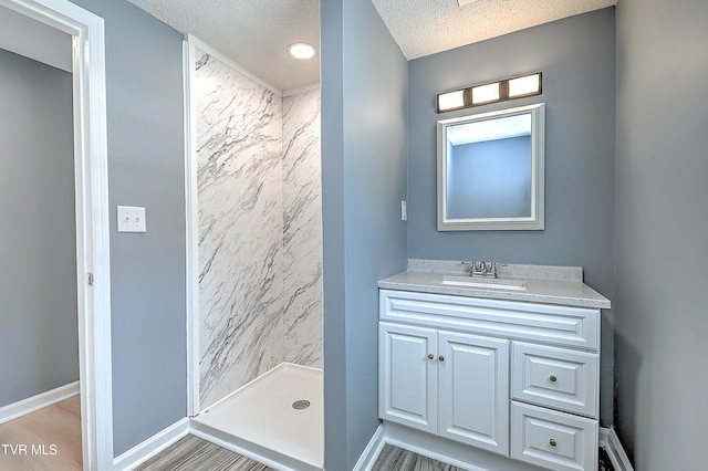 bathroom featuring a shower, vanity, a textured ceiling, and wood-type flooring