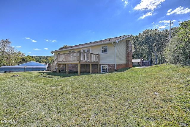 rear view of property with a deck and a yard