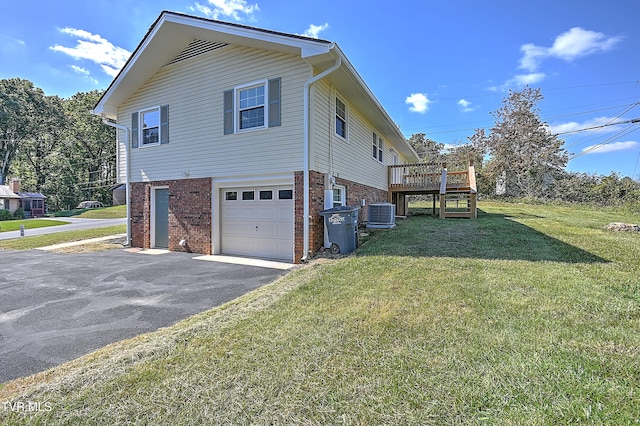 view of side of property with a garage, a deck, a yard, and central air condition unit