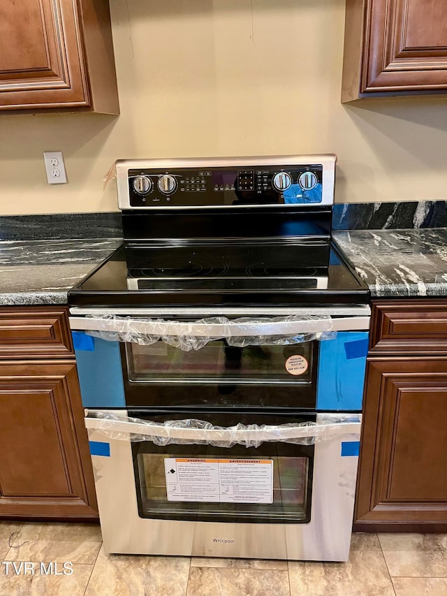 interior details with double oven range and dark stone countertops