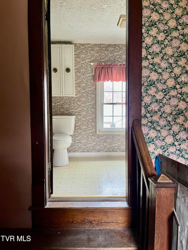 bathroom with toilet and a textured ceiling