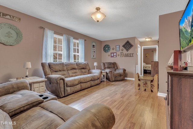 living room featuring light hardwood / wood-style flooring and a textured ceiling