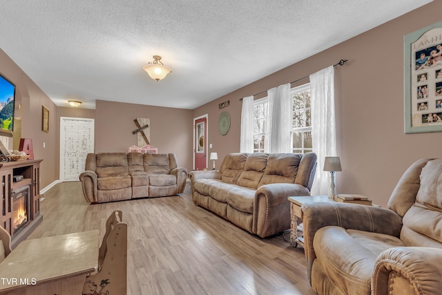 living room featuring light hardwood / wood-style floors and a textured ceiling