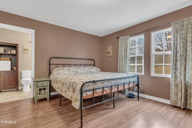 bedroom featuring light hardwood / wood-style floors and a textured ceiling