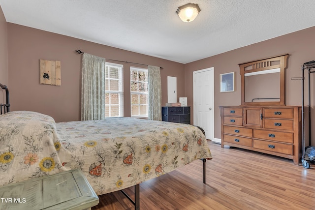 bedroom with light hardwood / wood-style floors and a textured ceiling