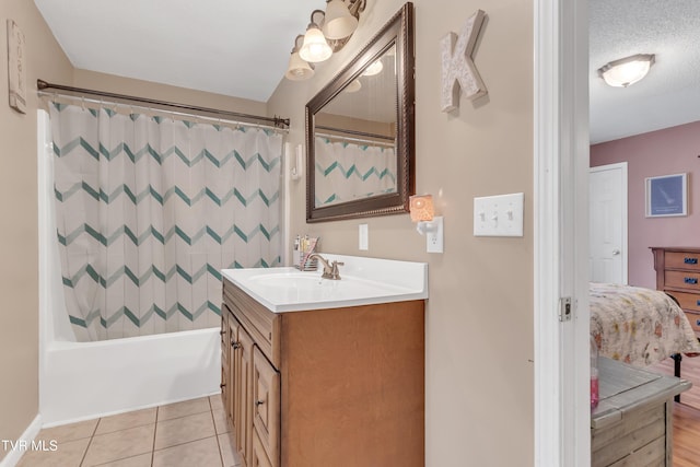 bathroom featuring tile patterned flooring, vanity, shower / bath combination with curtain, and a textured ceiling