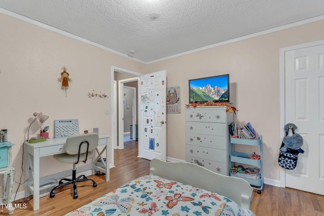 bedroom with a textured ceiling, hardwood / wood-style flooring, and crown molding