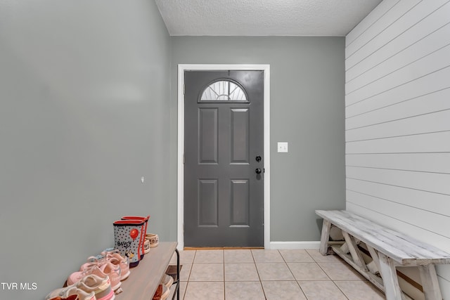 tiled foyer entrance featuring a textured ceiling