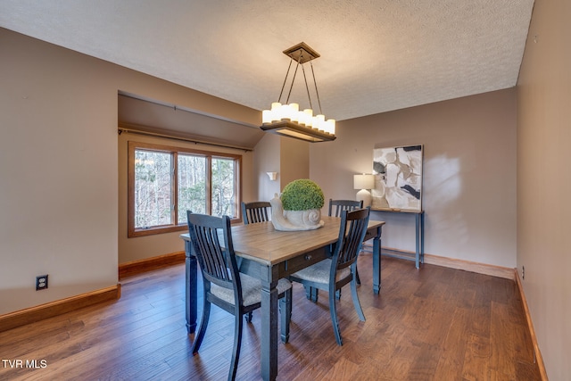 dining space featuring lofted ceiling, a textured ceiling, and dark wood-type flooring