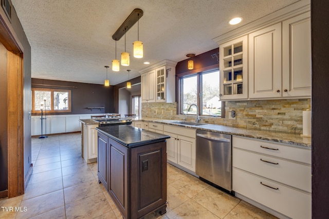 kitchen with dishwasher, sink, hanging light fixtures, kitchen peninsula, and dark stone counters