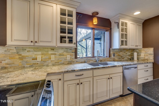 kitchen featuring dishwasher, sink, light stone counters, backsplash, and range