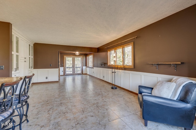 living area featuring a textured ceiling and french doors