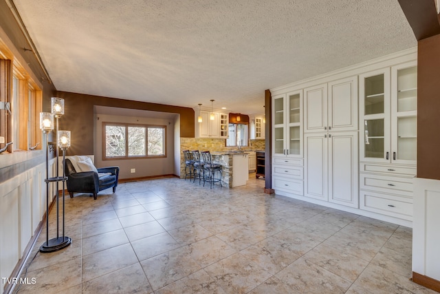 unfurnished living room featuring a textured ceiling and ornamental molding