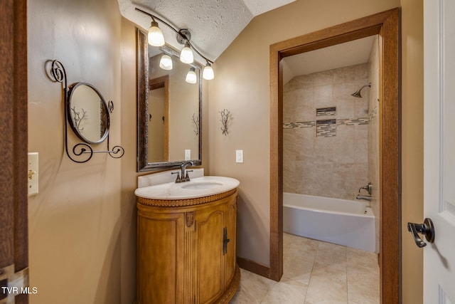 bathroom with tiled shower / bath combo, tile patterned flooring, lofted ceiling, a textured ceiling, and vanity