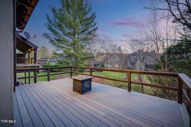 deck at dusk featuring a fire pit