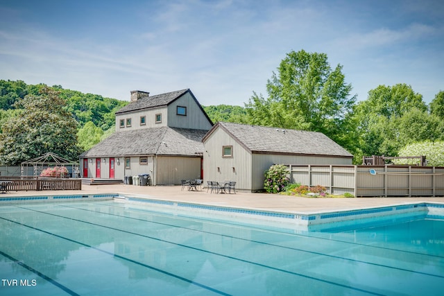 view of swimming pool with an outbuilding and a patio