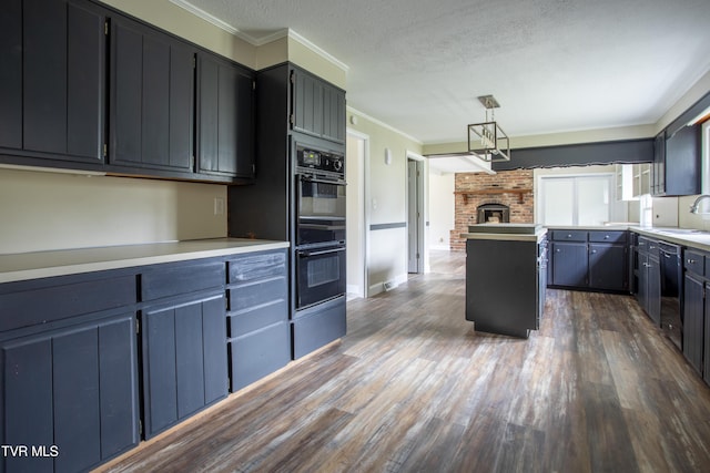 kitchen featuring pendant lighting, dark hardwood / wood-style floors, crown molding, and black appliances