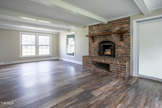 unfurnished living room featuring beam ceiling, crown molding, dark wood-type flooring, and a brick fireplace