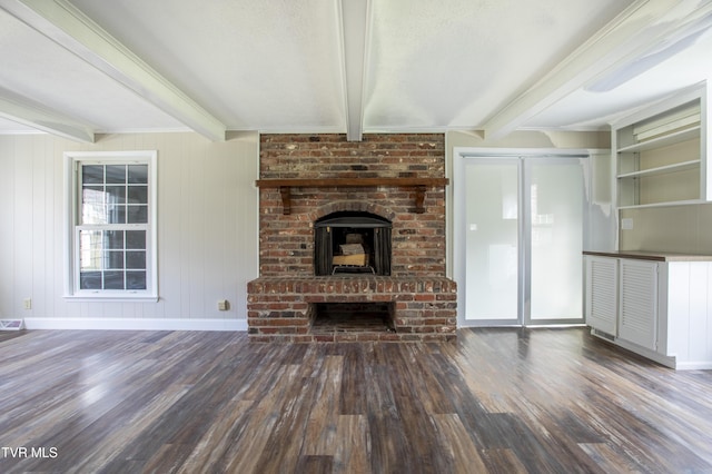 unfurnished living room with beamed ceiling, wooden walls, a fireplace, and dark wood-type flooring