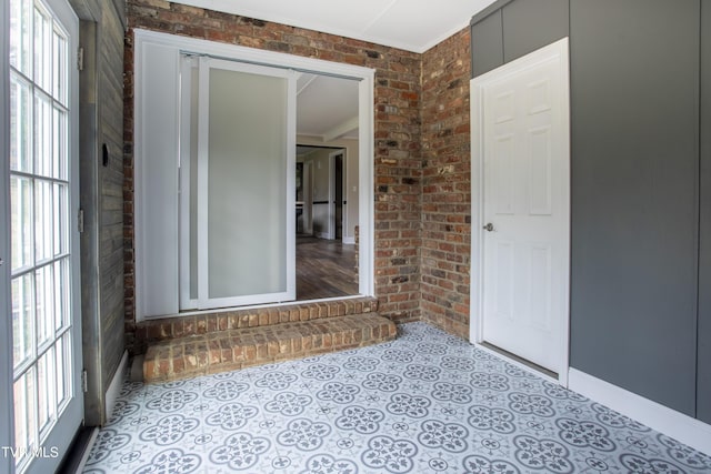 unfurnished room with crown molding and brick wall