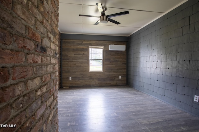 empty room featuring hardwood / wood-style flooring, ceiling fan, and an AC wall unit